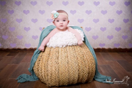 Photographe Marseillant Bebe Dans Un Pannier En Fibre Avec Des Coeur Violet En Fond